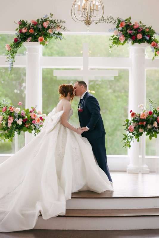 Couple kissing under florsist designed artwork