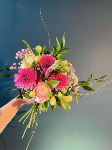 Person holding colorful bouqet of roses and flowers